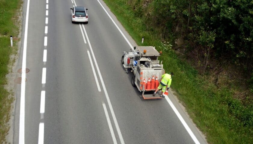 Vozilo za obeležavanje puteva obnavlja horizontalnu signalizaciju na kolovozu dok saobraćaj prolazi.